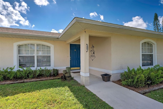 property entrance with a lawn