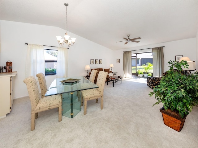 carpeted dining area with ceiling fan with notable chandelier and vaulted ceiling