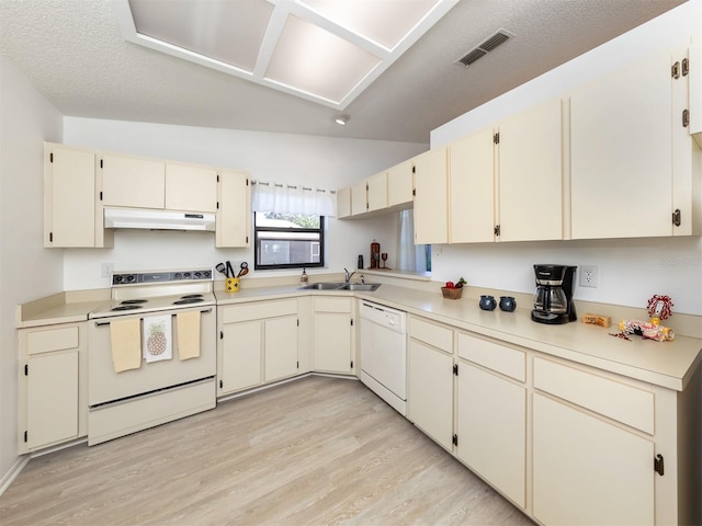 kitchen featuring lofted ceiling, white appliances, light hardwood / wood-style flooring, and sink