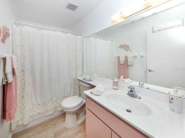 bathroom with vanity, toilet, and hardwood / wood-style flooring