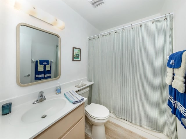 bathroom featuring wood-type flooring, vanity, toilet, and curtained shower