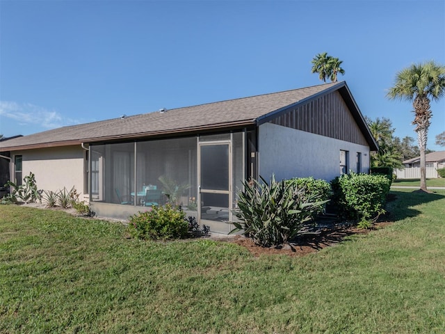 view of side of home featuring a lawn and a sunroom