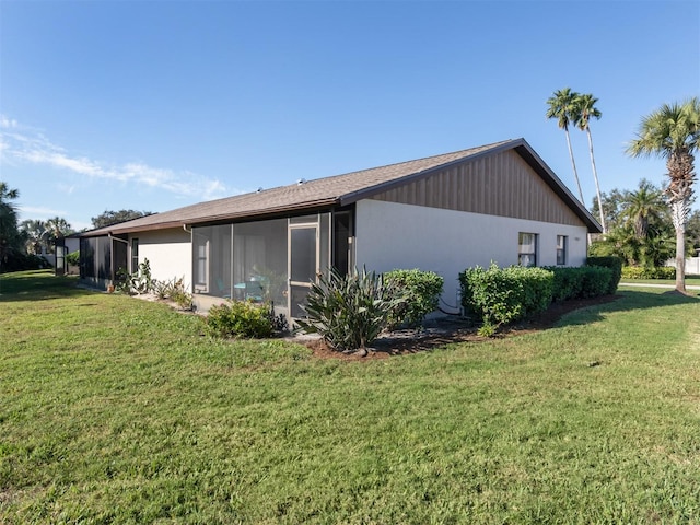 view of home's exterior with a sunroom and a lawn