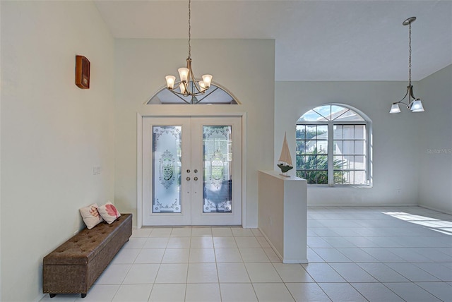 tiled entryway with a chandelier, french doors, and a healthy amount of sunlight