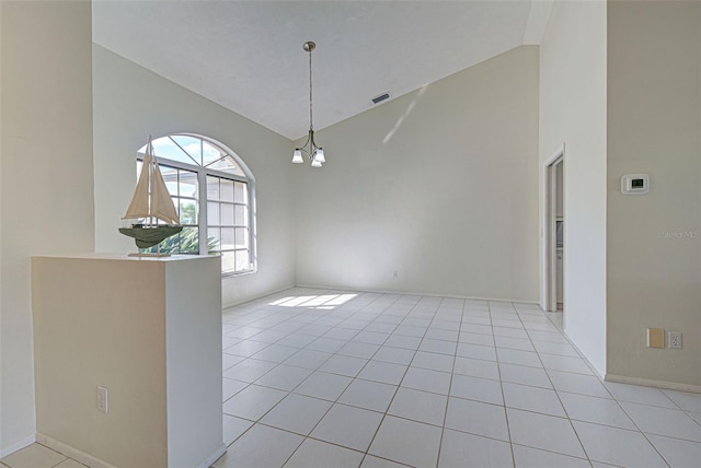 tiled empty room featuring an inviting chandelier and high vaulted ceiling