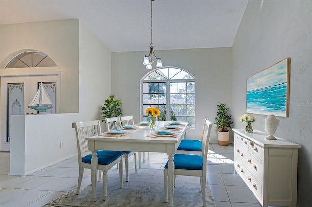 dining space featuring high vaulted ceiling, an inviting chandelier, and tile patterned flooring