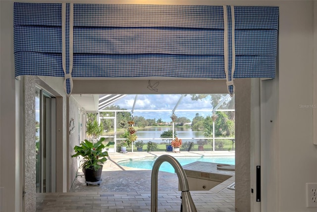 view of swimming pool featuring a water view, a patio area, and a lanai