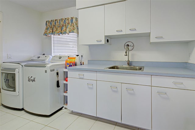 clothes washing area with sink, light tile patterned flooring, washer and dryer, and cabinets