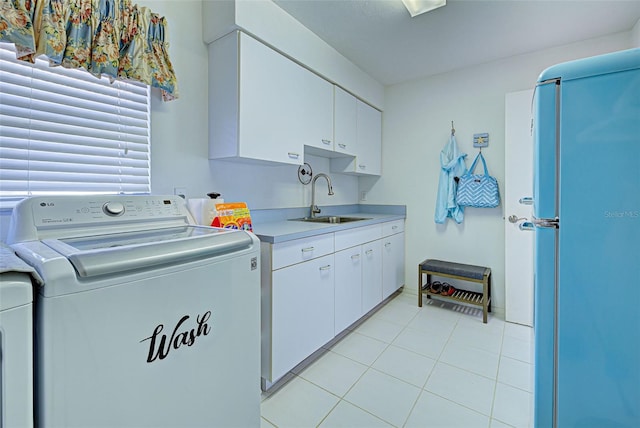 laundry area with cabinets, sink, washing machine and dryer, and light tile patterned floors