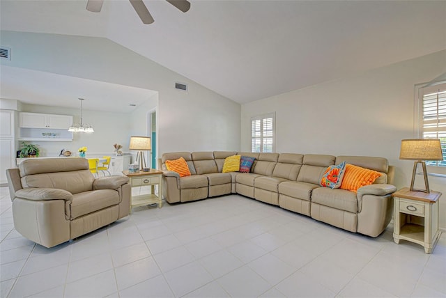 living room featuring vaulted ceiling, light tile patterned flooring, a wealth of natural light, and ceiling fan with notable chandelier