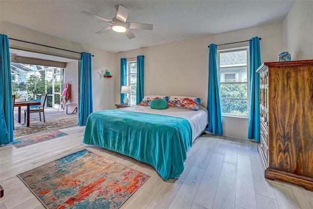 bedroom with multiple windows, light wood-type flooring, and ceiling fan