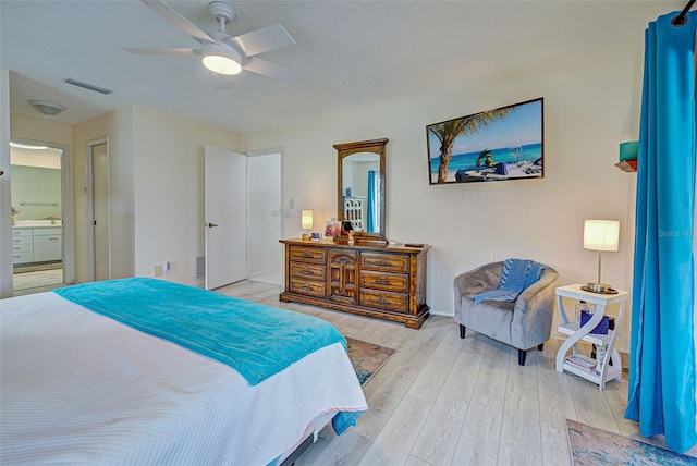 bedroom with light hardwood / wood-style floors, ensuite bathroom, and ceiling fan