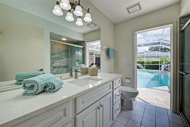 bathroom featuring a shower with door, vanity, toilet, and tile patterned floors