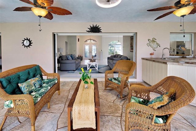 living room with sink, french doors, and ceiling fan