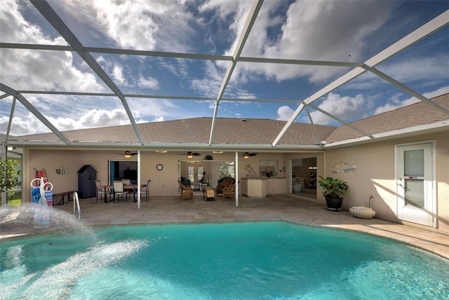 view of swimming pool featuring a patio, glass enclosure, and ceiling fan