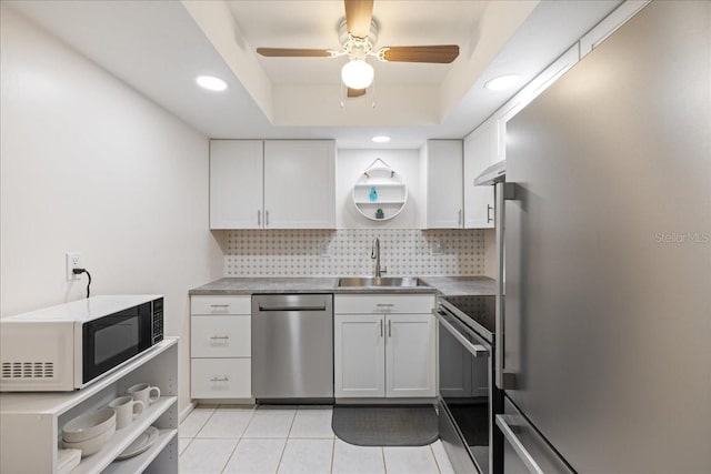 kitchen with ceiling fan, white cabinets, sink, tasteful backsplash, and stainless steel appliances