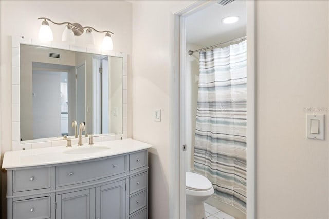 bathroom with tile patterned flooring, a shower with curtain, vanity, and toilet