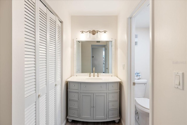 bathroom featuring hardwood / wood-style floors, vanity, and toilet