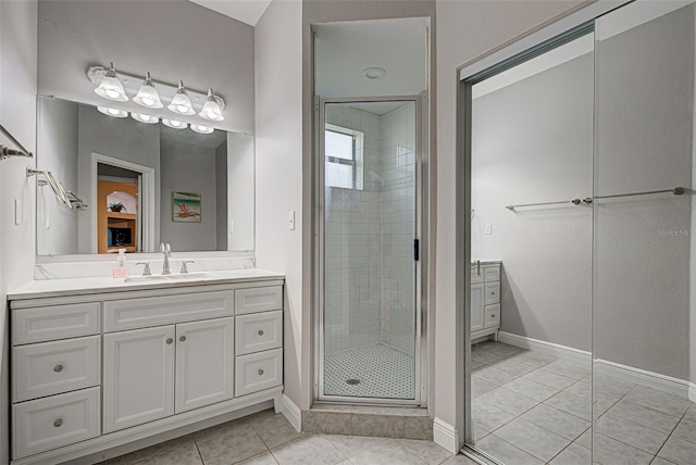 bathroom featuring tile patterned floors, vanity, and a shower with shower door