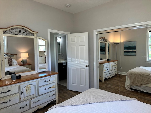 bedroom featuring dark wood-type flooring and ensuite bath