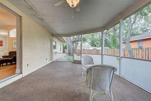 unfurnished sunroom featuring ceiling fan