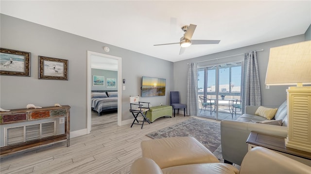 living room with ceiling fan and light hardwood / wood-style flooring