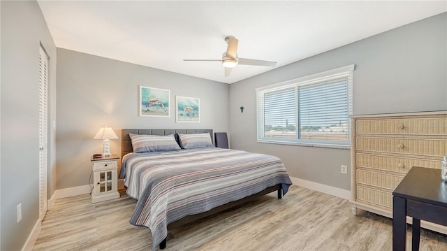 bedroom with ceiling fan, light wood-type flooring, and a closet