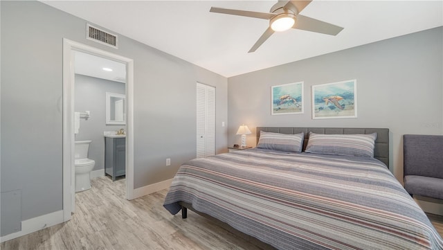 bedroom featuring ceiling fan, light hardwood / wood-style floors, connected bathroom, and a closet