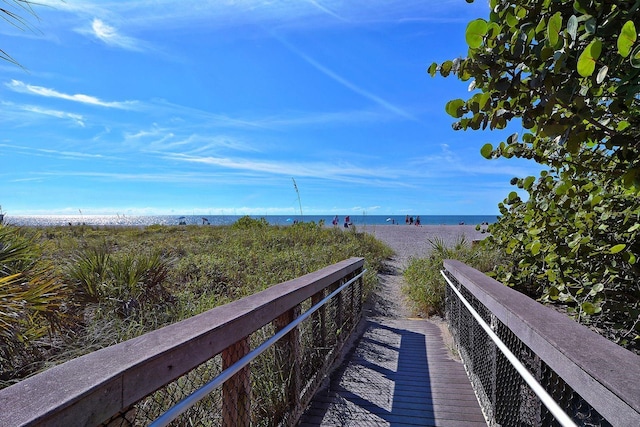 view of property's community with a water view and a beach view