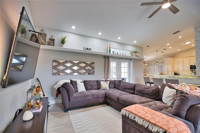 living room featuring light wood-type flooring, vaulted ceiling, ceiling fan, and french doors