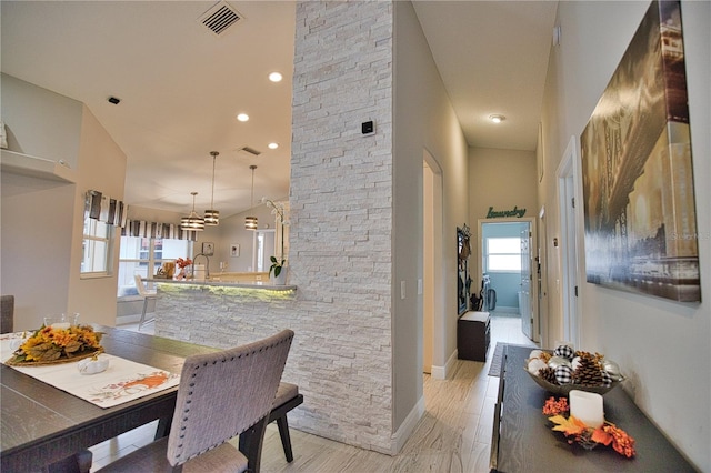 dining room featuring a high ceiling, light hardwood / wood-style floors, and a wealth of natural light