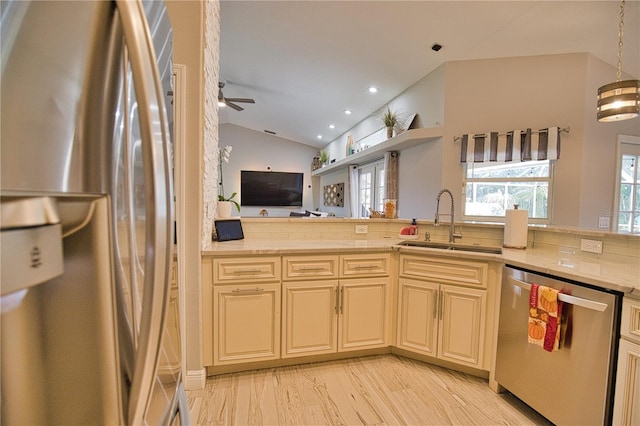 kitchen featuring lofted ceiling, sink, tasteful backsplash, cream cabinets, and appliances with stainless steel finishes