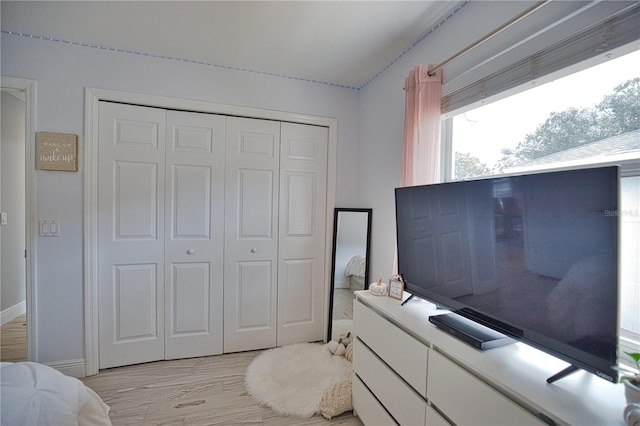 bedroom with light hardwood / wood-style flooring and a closet