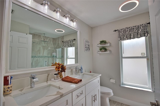 bathroom with walk in shower, vanity, toilet, and a wealth of natural light