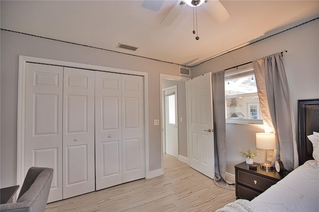 bedroom with ceiling fan, light wood-type flooring, and a closet