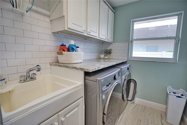 washroom with cabinets, sink, and washing machine and dryer