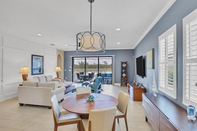 tiled dining room with ornamental molding and a wealth of natural light