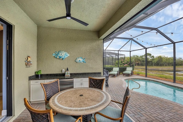 exterior space with a patio, glass enclosure, and ceiling fan