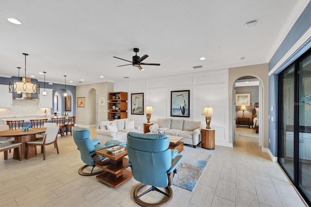 living room featuring ornamental molding, light hardwood / wood-style floors, and ceiling fan