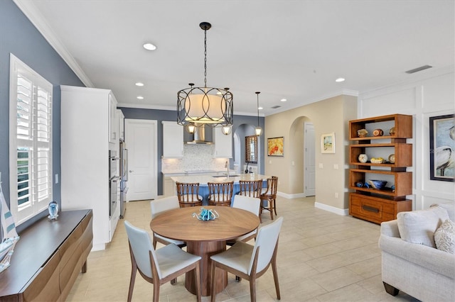 tiled dining room featuring sink, plenty of natural light, and crown molding