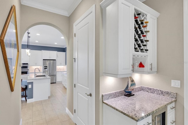 interior space featuring crown molding, light tile patterned flooring, beverage cooler, and sink