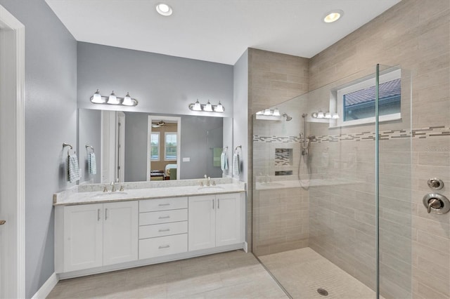 bathroom with ceiling fan, vanity, and tiled shower