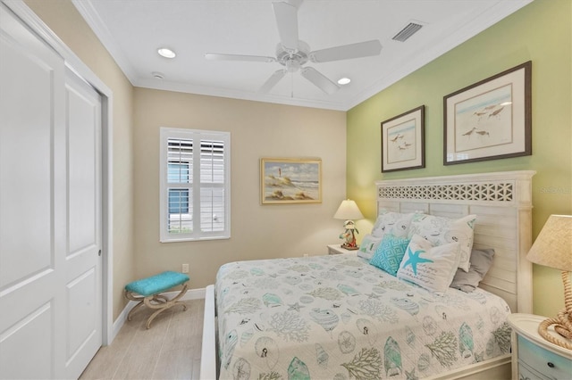 bedroom featuring ornamental molding, a closet, ceiling fan, and light hardwood / wood-style flooring