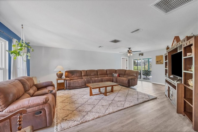 living room featuring light hardwood / wood-style flooring and ceiling fan