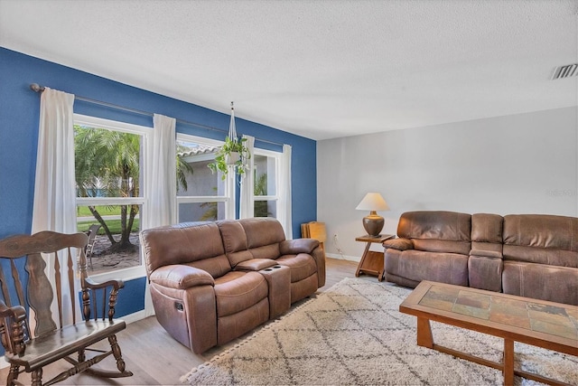 living room featuring light hardwood / wood-style floors and a textured ceiling