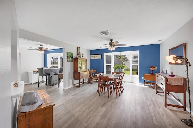 dining area with light hardwood / wood-style floors and ceiling fan