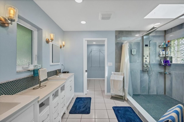 bathroom with tile patterned floors, vanity, a skylight, and a shower with curtain