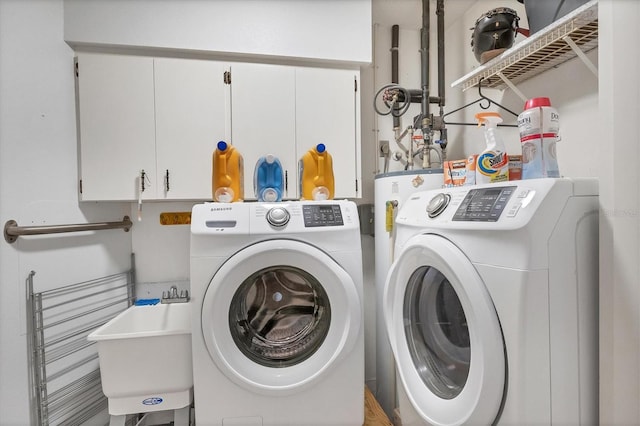 washroom featuring sink, washing machine and clothes dryer, and cabinets