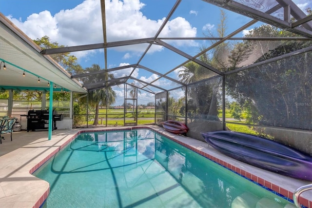 view of pool with glass enclosure, a patio area, and grilling area