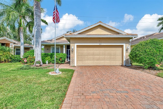 single story home featuring a garage and a front lawn